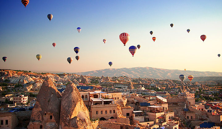 Sunrise in Cappadocia, Turkey, with balloons and typical fairy chimney